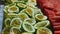 Closeup panorama down at assortment of sliced tropical fruits at food court