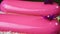 Closeup panorama down at pink glazed oval desserts with violet flowers decoration