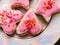 Closeup panorama on heap of assorted white and pink macaroons with white creamy filling served on big plate