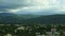 Closeup panorama at little city against fluffy white clouds above blue mountains