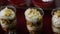 Closeup panorama on three banana mousse dessert in round plastic glass on red background