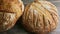 Closeup panorama of two whole round bread on wooden table