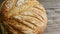 Closeup panorama of whole round bread loaf on wooden table