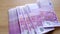 Closeup paper 500 euro banknotes of eu slowly fall on old wooden table, slide along it, concept of cash, payments, savings,