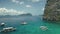 Closeup passenger boat at ocean bay with green cliff shore at aerial view. Tropic seascape at sand beach