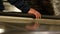 Closeup of a passenger hand lifting on escalator handrail. Female hand on black rubber handrail of an escalator moving up