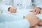 Closeup of patients hands and doctor taking notes.