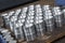 Closeup pattern of shiny circular precision stainless steel industrial machine parts arranged in rows. Steel products to