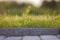 Closeup of pavement curb with green grass lawn behind