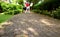 Closeup the paving pathway in the public park with blurry exercising female in afar