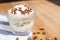 Closeup of a pecan dessert on the wooden table coffee beans, a striped tea towel blurred background