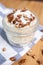 Closeup of a pecan dessert on the wooden table coffee beans, striped tea towel blurred background