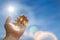 Closeup of pendant in the shape of the star of David on the hand of a man on blue sky background.