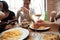 Closeup of people drinking wine and eating pasta at table