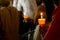 Closeup of people holding candle vigil in dark seeking hope