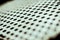 Closeup perforated aluminium sheet of metal texture. Surface with depth of field, abstract industrial mesh background