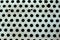 Closeup perforated aluminium sheet of metal texture. Surface with depth of field, abstract industrial mesh. Top view