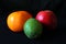 Closeup of Persimmon, Apple and Feijoa fruits against black background