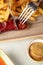 Closeup of a person cutting a grilled sausage next to fries