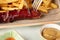 Closeup of a person cutting a grilled sausage next to fries