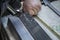 Closeup of a person drilling a piece of metal with a blurry background