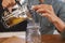 Closeup, person and hands with brewing tea to start morning, cafe and table before work. Plunger, pour, fresh and