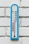 Closeup photo of alcohol thermometer on white wall