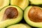 Closeup photo of avocado cut to half, brown seeds visible, with