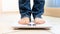 Closeup photo of barefoot person in jeans standing on weights