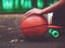 Closeup photo basketball ball with girl sitting on plastic orange penny