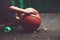 Closeup photo basketball ball with girl sitting on plastic orange penny