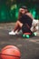 Closeup photo basketball ball with girl sitting on plastic orange penny