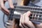 Closeup photo of bass guitar player hands, soft selective focus, live music theme
