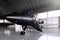 Closeup photo of Black Matte Luxury Generic Design Private Jet parking in hangar airport. Concrete floor. Business
