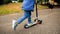 Closeup photo of boy`s feet riding on children kick scooter at park