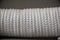 Closeup photo of Coiled white Nylon Rope on gray background.