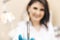 Closeup photo of female dentist in the dental room holding oral syringe.