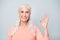 Closeup photo of kind wise old lady having wavy curly long hair making ok sign  grey background