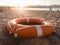 Closeup photo of orange plastic ring for saving drowning people on the sea lying on beach