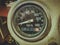 Closeup photo of a round black speedometer of an old Soviet motorcycle