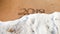 Closeup photo of sea waves rolling over 2019 numbers written on wet sand at beach. Concept of New Year, Christmas and