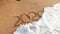 Closeup photo of sea waves rolling over 2020 New Year numbers written on wet sand