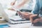 Closeup photo team job. Young business crew working with new startup project. Notebook on wood table,smartphone hands.Analyze plan