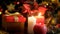 Closeup photo of three candles burning next Christmas gifts and decorative wreath