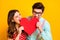 Closeup photo two people attractive lady handsome guy couple look eyes angry biting big paper heart wear red dotted