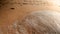 Closeup photo of wet sand and footrpints on the sea beach at sunsent