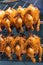 Closeup photo of whole roasted chicken hang at restaurant`s showcase