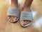 Closeup photo of woman feet in grey slipper sandal