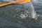 Closeup photo of wooden paddle used for rowing. Paddle rowing in the water, lake Bled on a sunny day