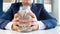 Closeup photo of young greedy businesman holding glass jar full of money in hands